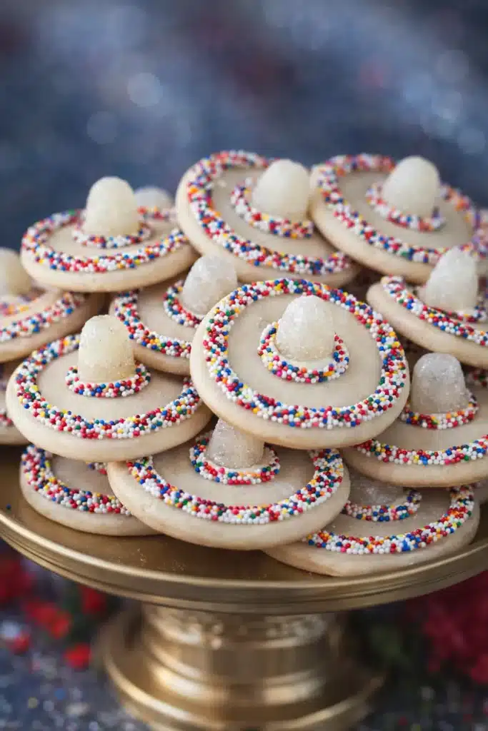Cinco de Mayo sombrero cookies decorated with rainbow sprinkles and gumdrops on a dessert plate