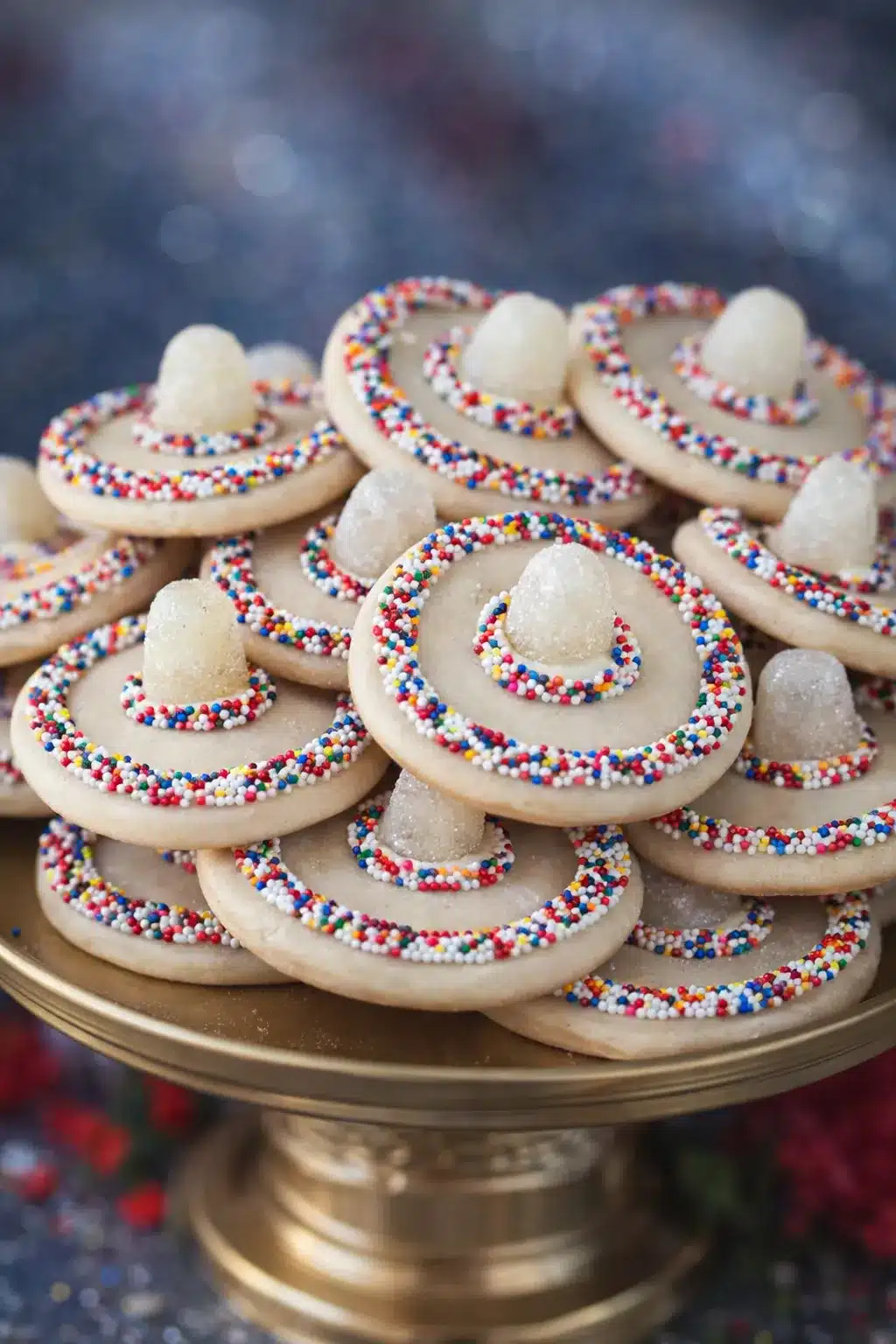 Cinco de Mayo sombrero cookies decorated with rainbow sprinkles and gumdrops on a dessert plate