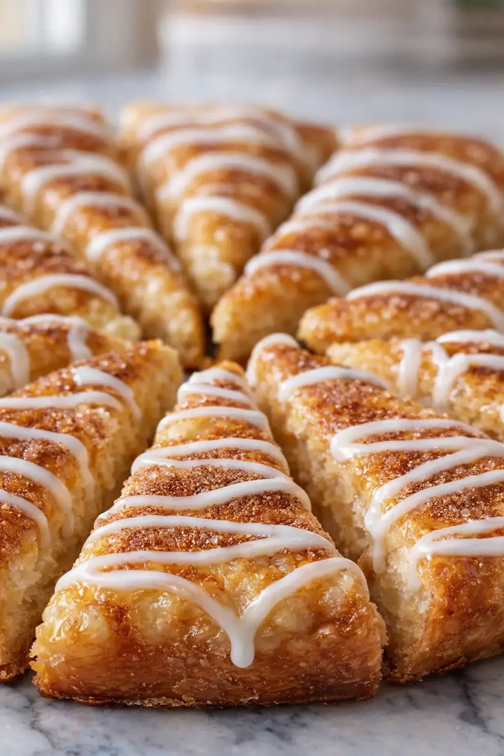 Cinnamon sugar crescent pizza slices with vanilla glaze drizzle on flaky golden pastry