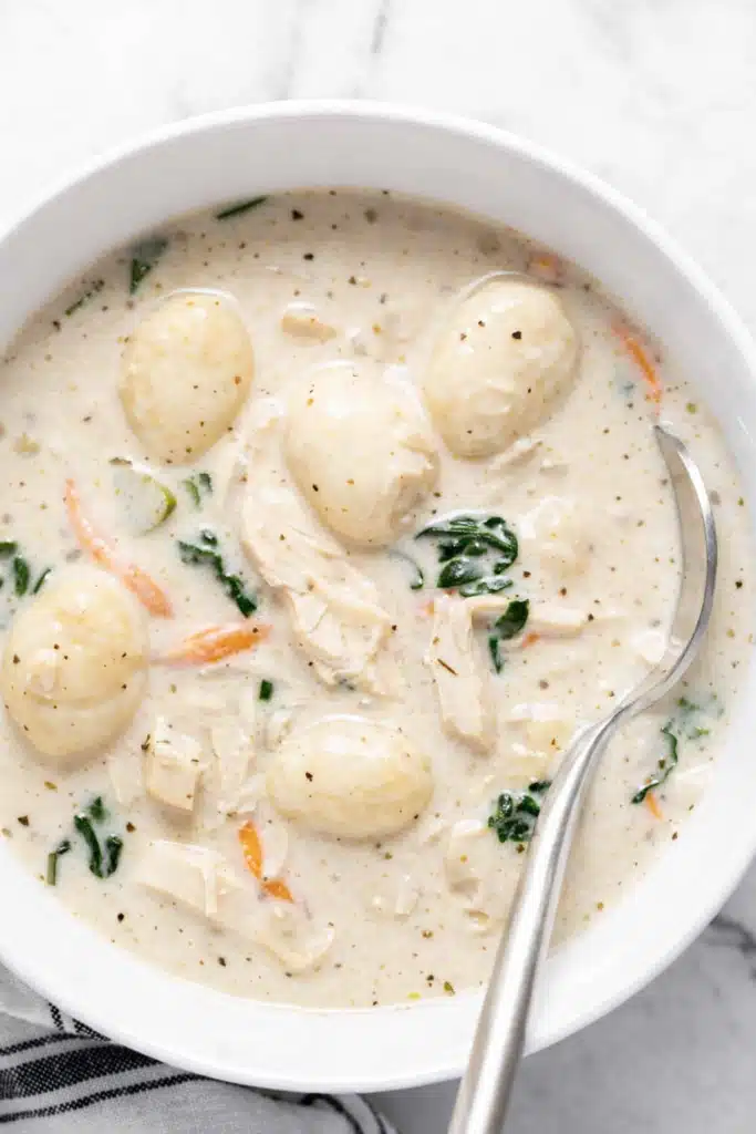Creamy chicken gnocchi soup with shredded chicken, spinach, and potato gnocchi in a bowl