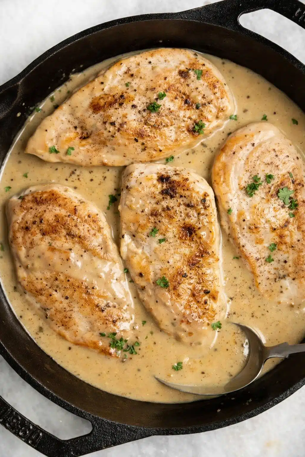 Creamy ranch chicken breasts in skillet with rich herb sauce and parsley garnish
