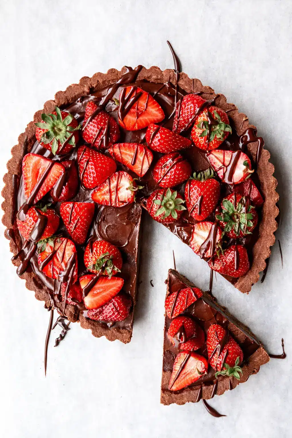 home 7 Dark chocolate strawberry tart with glossy ganache and fresh strawberries on marble surface