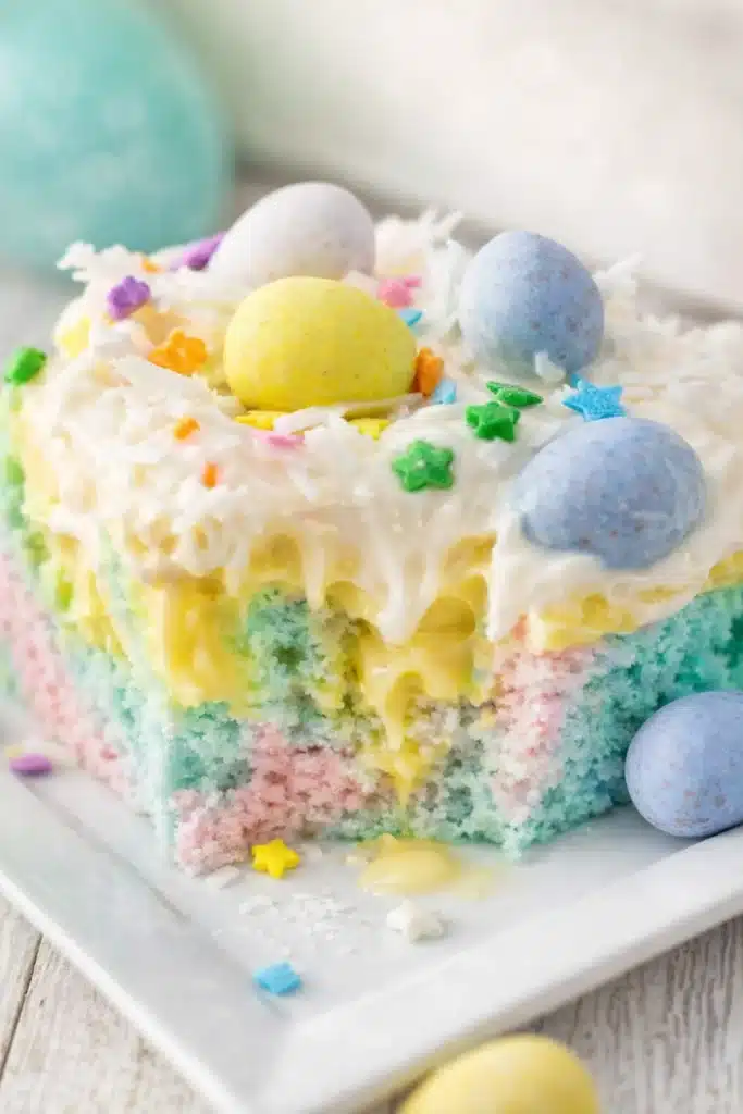Easter Poke Cake Simple Colorful Easter Dessert 8 Colorful Easter poke cake slice with pudding filling and pastel candy eggs