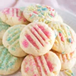 Easter shortbread cookies with pastel sprinkles stacked on a plate