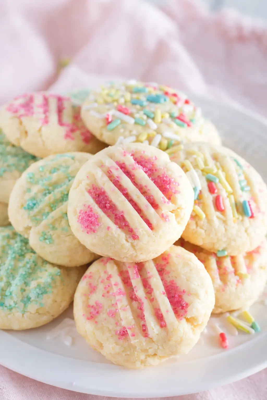 Easter shortbread cookies with pastel sprinkles stacked on a plate