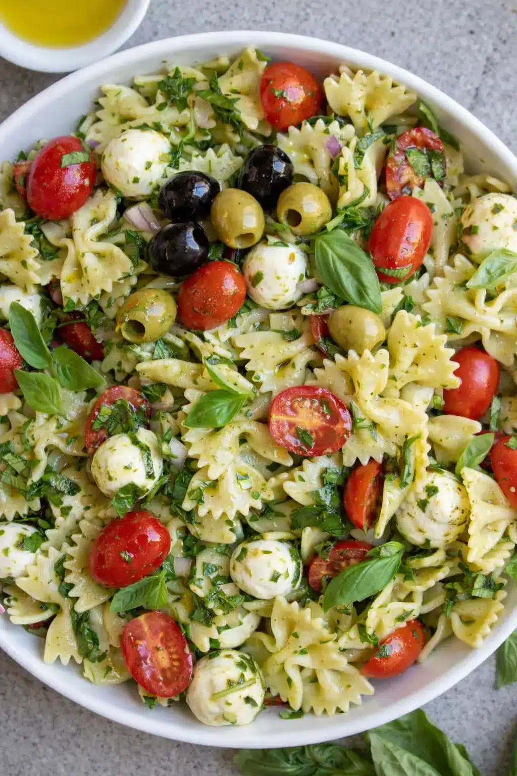 home 20 Bow tie pasta salad with pesto, cherry tomatoes, basil, and mozzarella in a bowl