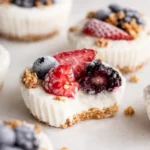 Frozen yogurt granola cups with berries and crunchy oat crust on a light background