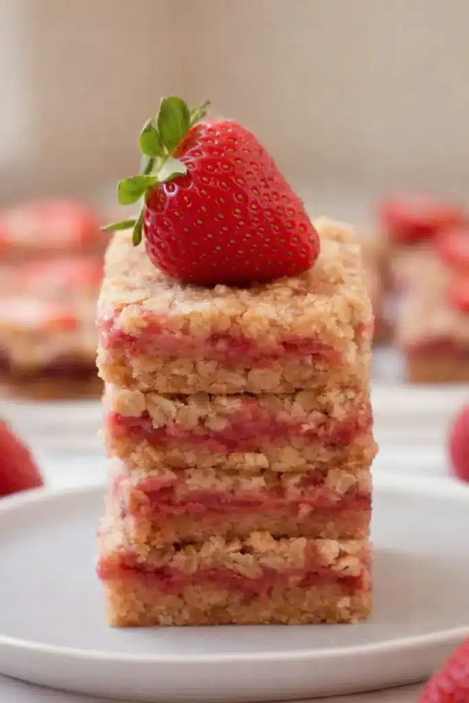 Healthy strawberry oatmeal bars stacked with fresh strawberry topping