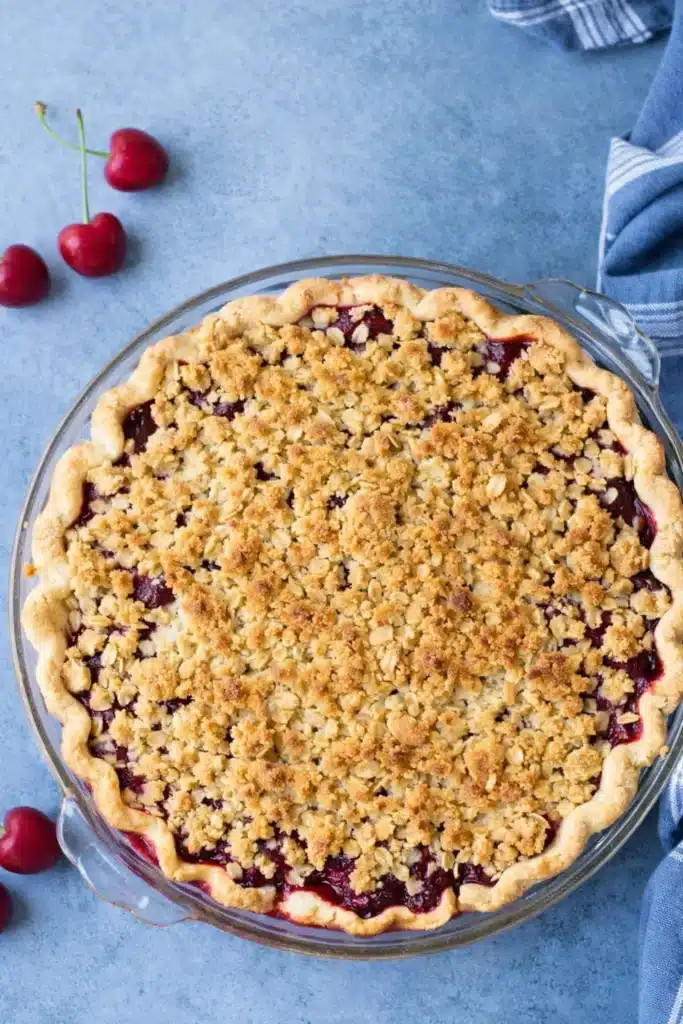 Cherry Crumble Pie with golden oat topping in glass pie dish
