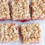 Homemade Rhubarb Crumble Bars Recipe That Feels Amazing 7 Homemade rhubarb crumble bars with pink filling and golden oat topping on parchment