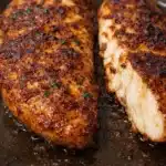 Juicy air fryer chicken breast with crispy paprika seasoning sliced on a dark plate