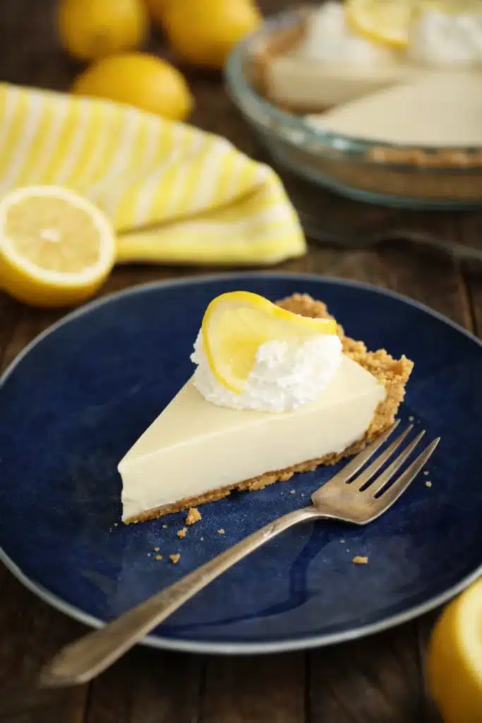 Slice of lemon cream pie with whipped cream and graham cracker crust