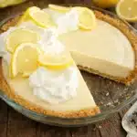 Slice of lemon cream pie with whipped cream topping and graham cracker crust