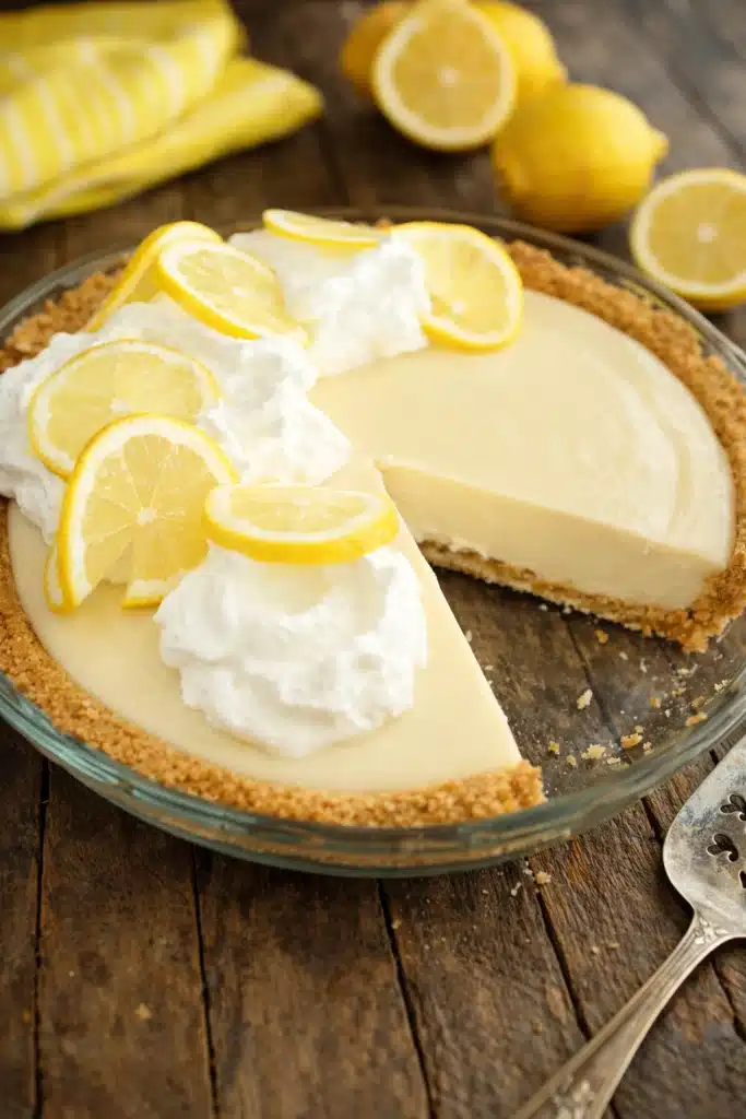 Slice of lemon cream pie with whipped cream topping and graham cracker crust