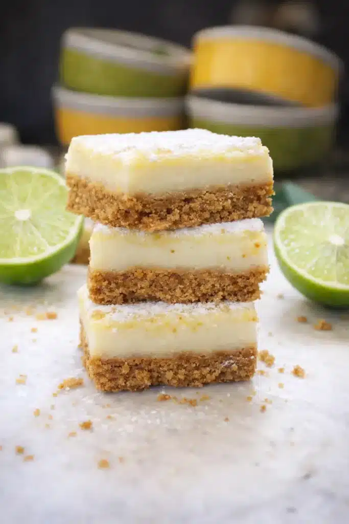Stacked lime margarita bars with creamy lime filling and graham cracker crust topped with powdered sugar