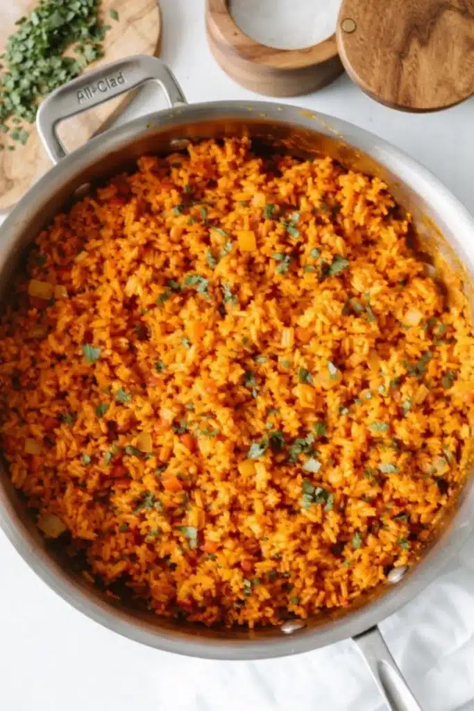 Mexican rice cooked in a skillet with tomato, vegetables, and cilantro