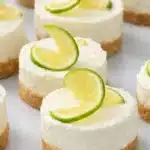 Mini margarita cheesecakes with lime slices and graham cracker crust on serving plate