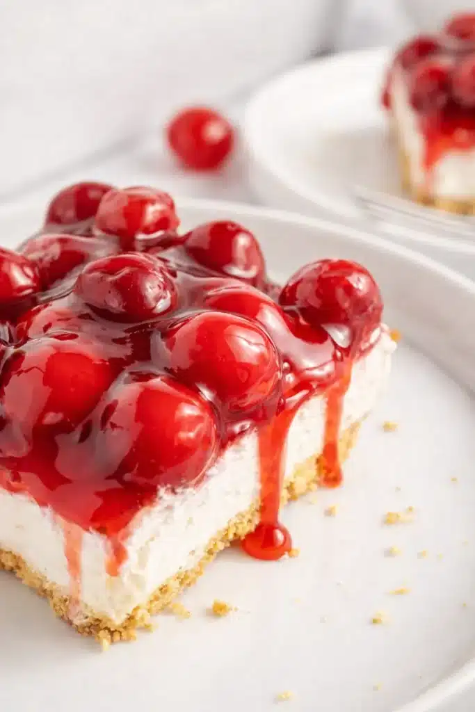 no bake cherry delight slice with creamy cheesecake layer and cherry pie topping