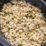 Creamy parmesan garlic chicken pasta with rotini and shredded chicken in a slow cooker