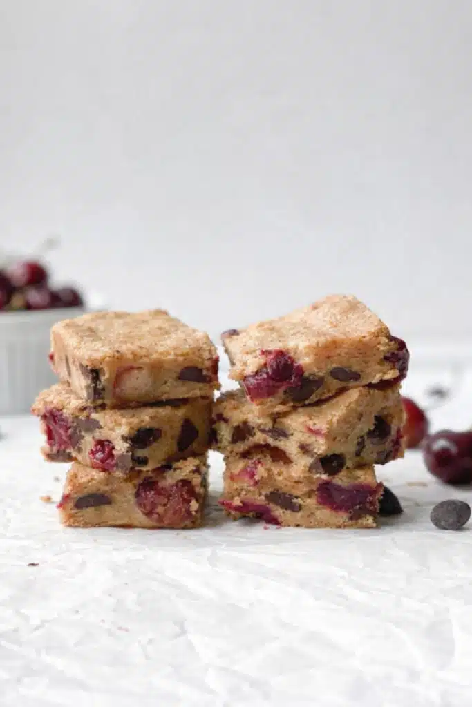 Stacked cherry chocolate chip blondies showing soft chewy texture and juicy cherries