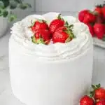Strawberry cream cake with whipped cream frosting and fresh strawberries on top