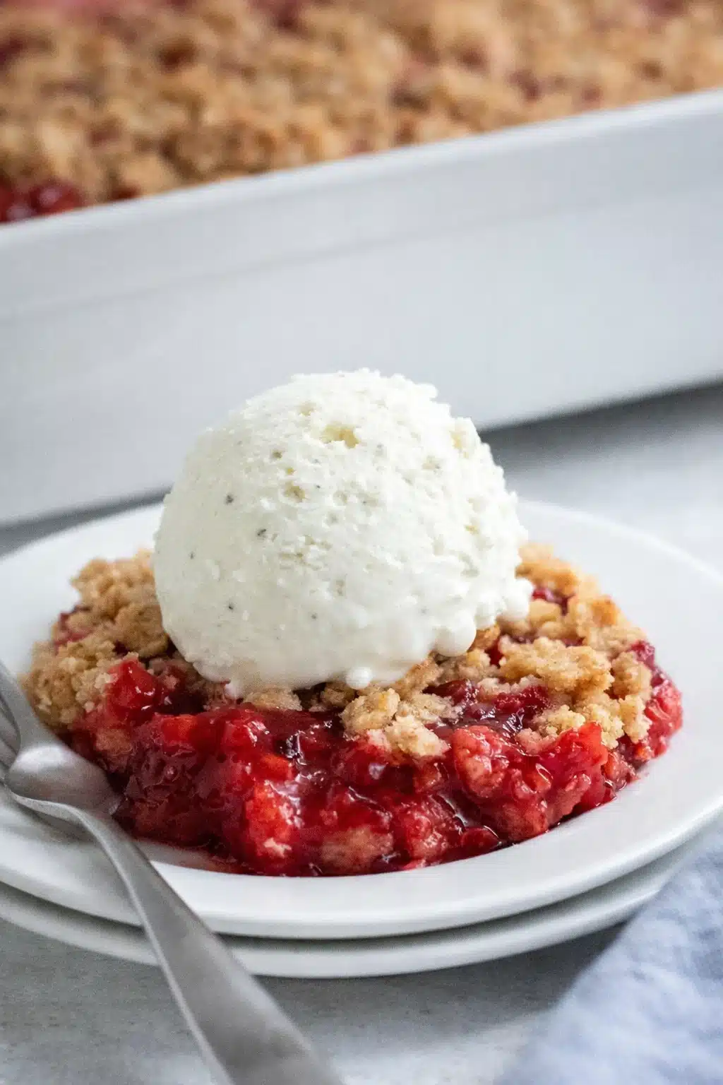 Strawberry crumble with vanilla ice cream on a plate