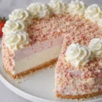 Strawberry crunch cheesecake with whipped cream and crumb topping on cake stand