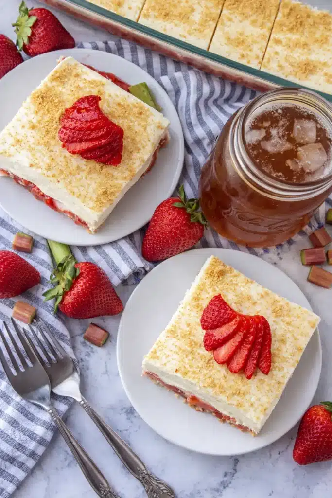 Strawberry Rhubarb Pudding Dessert | Easy Summer Favorite 5 Strawberry Rhubarb Pudding Dessert slices on plates with fresh strawberries