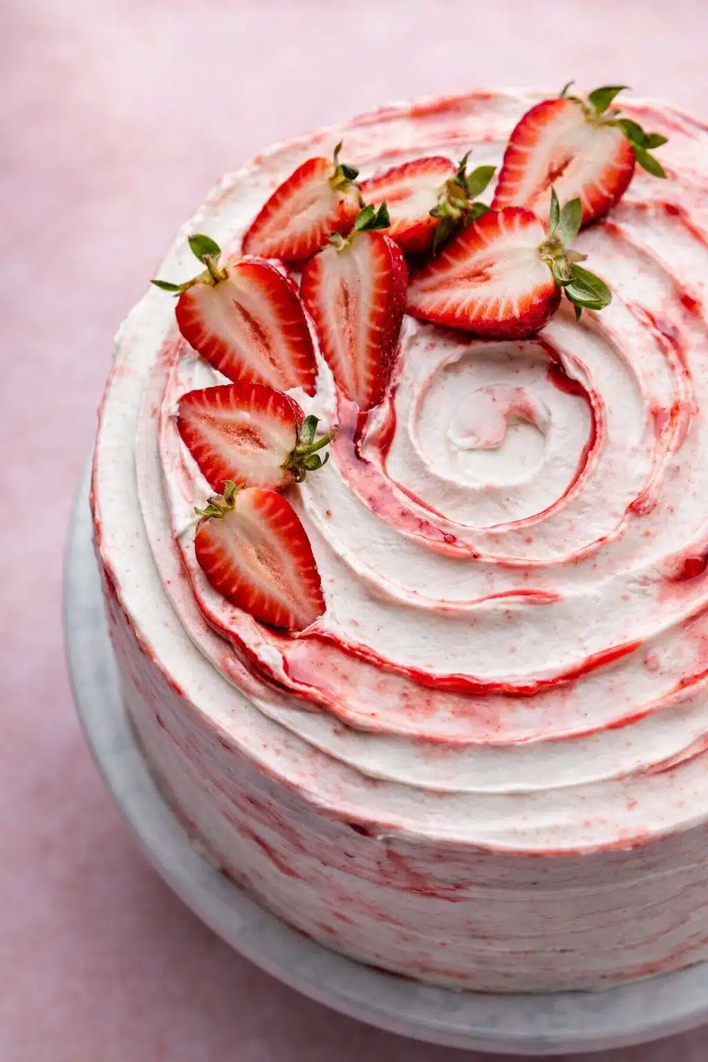 Strawberry shortcake layer cake with whipped cream frosting and fresh strawberry topping