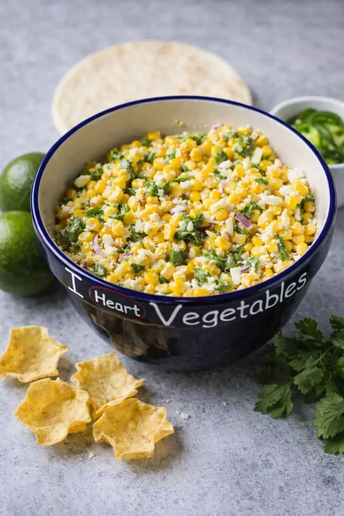 Creamy street corn salad with lime, jalapeño, cilantro, and cheese served in a bowl