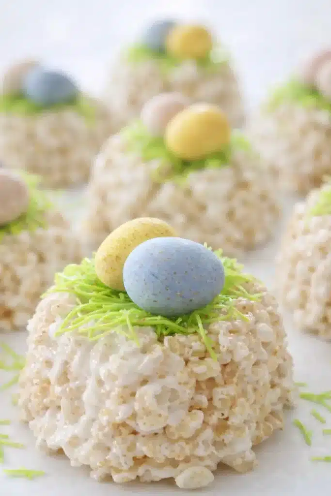 Easy Rice Krispie Easter nests topped with pastel candy eggs and green candy grass