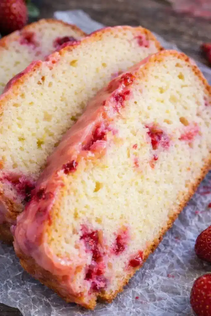 Easy Strawberry Pound Cake Recipe That Tastes Amazing 5 Easy Strawberry Pound Cake slices with pink glaze and baked strawberries