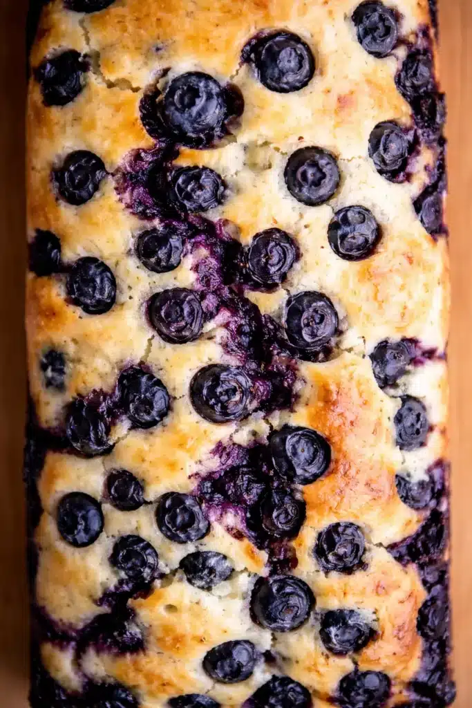 Close-up of lemon blueberry bread with juicy baked blueberries and golden moist loaf