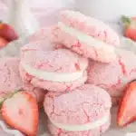 Strawberry cake mix sandwich cookies with pink sugar coating and creamy filling