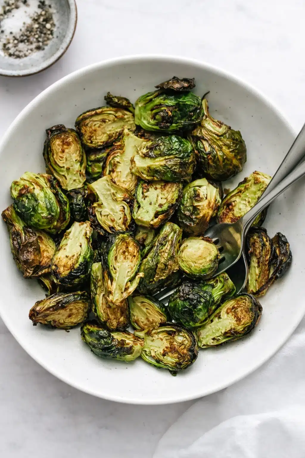 home 9 Crispy air fryer Brussels sprouts in a bowl with golden edges and tender green centers