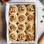 Unbaked apple cinnamon rolls with apple filling in baking dish