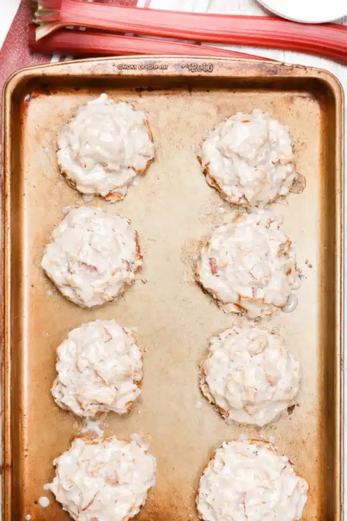 Baked rhubarb fritters on tray with vanilla glaze