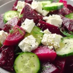 Vibrant beet feta salad with cucumber and dill in a white bowl