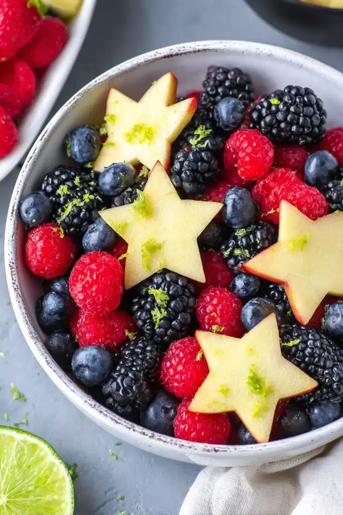 Berry fruit salad with blueberries, raspberries, blackberries, and apple stars in a bowl