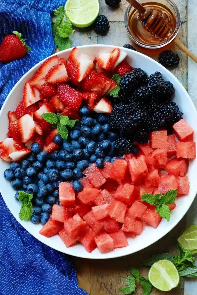 Berry Watermelon Fruit Salad ingredients with fresh berries and mint in bowl