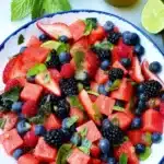 Berry watermelon fruit salad with fresh berries, mint, and lime in a bright summer bowl