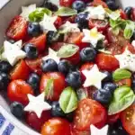 Blueberry cherry tomato caprese salad with mozzarella and basil in a white bowl