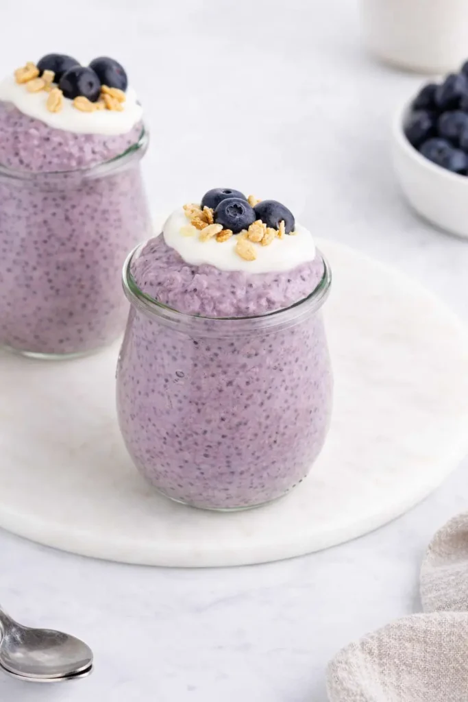 Blueberry chia pudding with yogurt, fresh blueberries, and granola in a glass jar