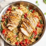 Bruschetta chicken pasta with grilled chicken, tomatoes, and basil in skillet