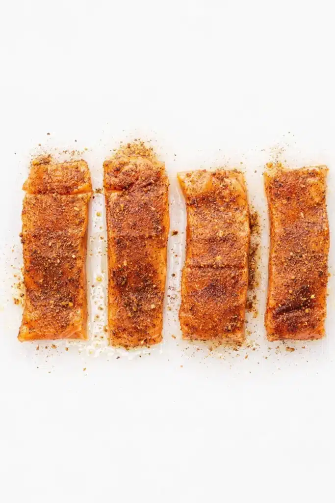 Cajun Honey Butter Salmon fillets seasoned with spices before cooking