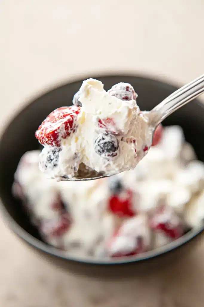 Cheesecake salad spoonful with creamy texture and fresh berries