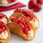 Cheesecake Tacos Easy Amazing Dessert Recipe 7 Cheesecake tacos with strawberry topping and creamy filling on marble surface