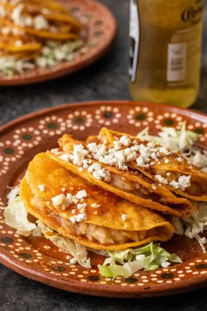 Cheesy Potato Tacos – Crispy, Creamy, and Perfect for Cinco de Mayo 5 Cheesy potato tacos with crispy tortillas, salsa, and queso fresco on rustic plate