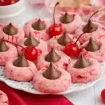 Cherry blossom cookies with chocolate centers and maraschino cherries on white plate