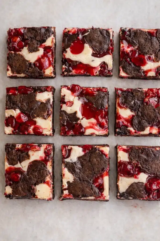 Cherry Cheesecake Brownies cut into squares with fudgy chocolate, creamy cheesecake, and cherry topping